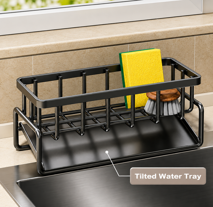 Black metal kitchen sink organizer tray with a tilted water tray, shown holding a yellow sponge and a scrubber in a sink. A label reads 'Tilted Water Tray'.